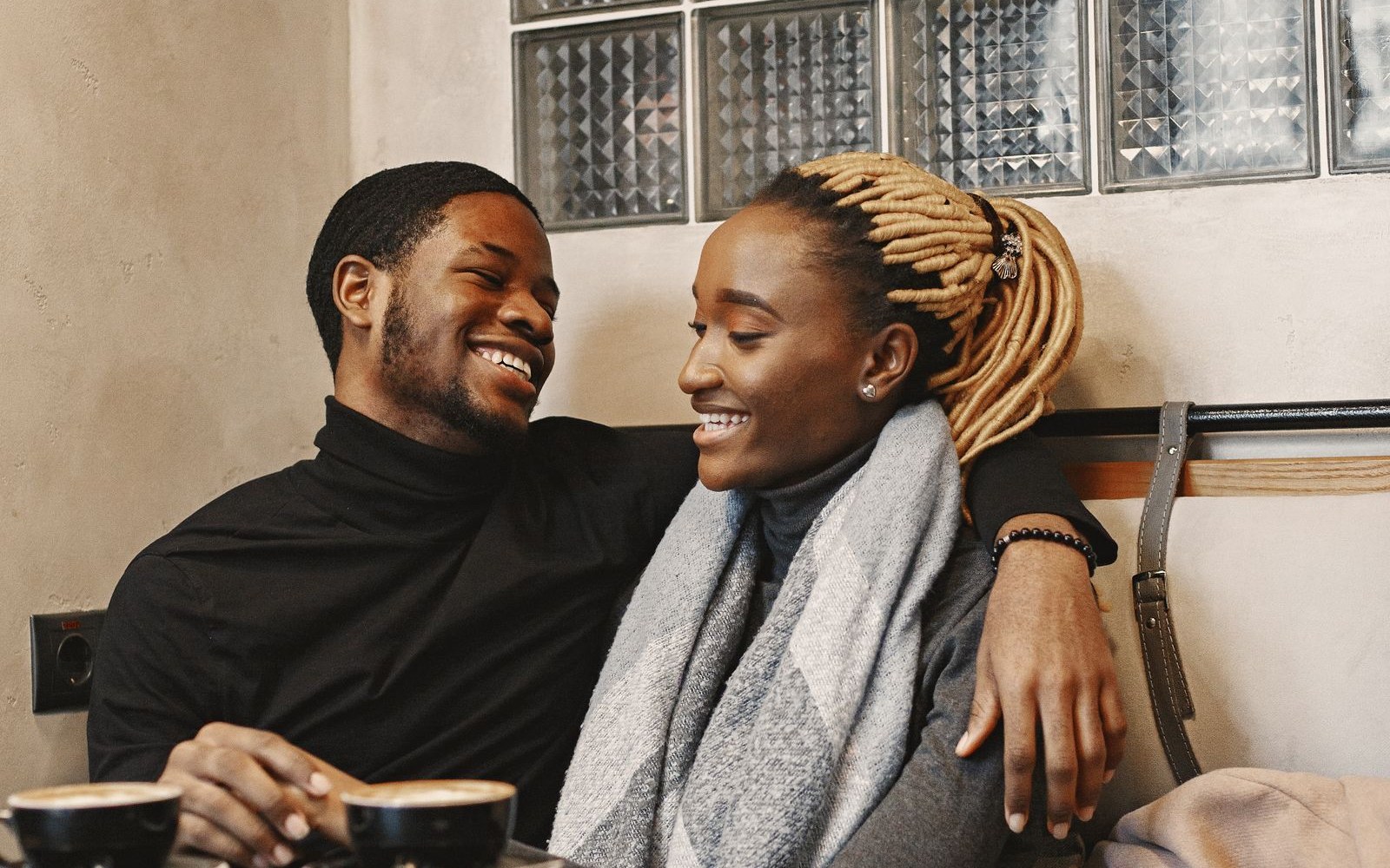A couple laughing together on a sofa