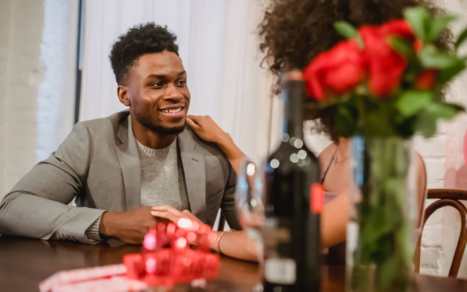 A couple at a dinner table with wine and flowers